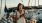 woman texting on a pier next to a boat