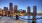 brick paved sidewalk along the water with city skyline